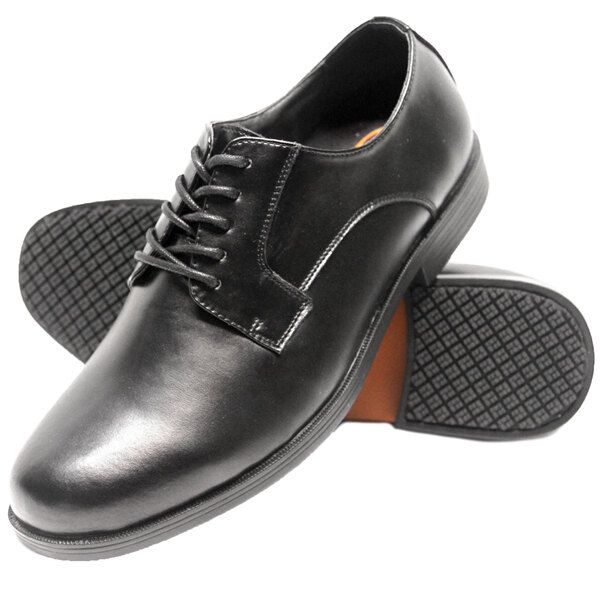 A close-up of a black Genuine Grip men's oxford shoe with rubber soles.