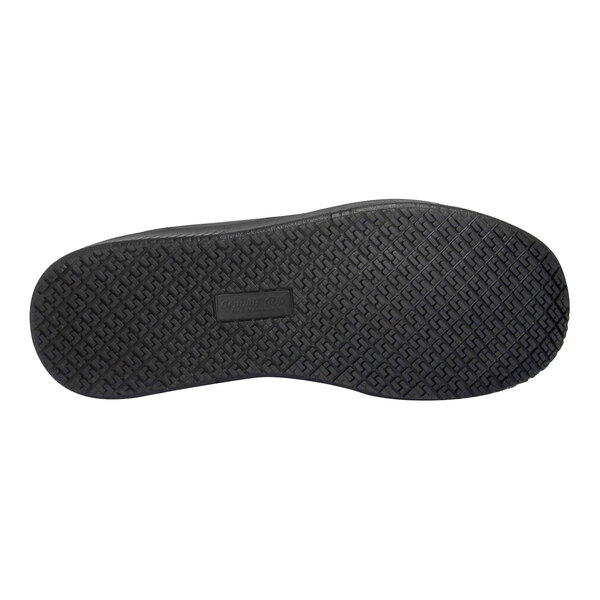 The image shows the black rubber outsole of a shoe with a textured, slip-resistant tread pattern.