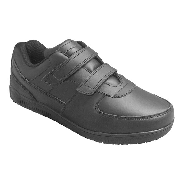 A black shoe with two hook and loop (Velcro) straps and a textured sole.