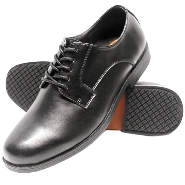 A pair of black Genuine Grip men's oxford shoes with rubber soles.