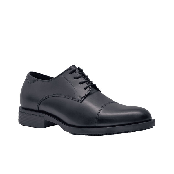 A close up of a black leather Shoes For Crews Senator men's dress shoe with laces.