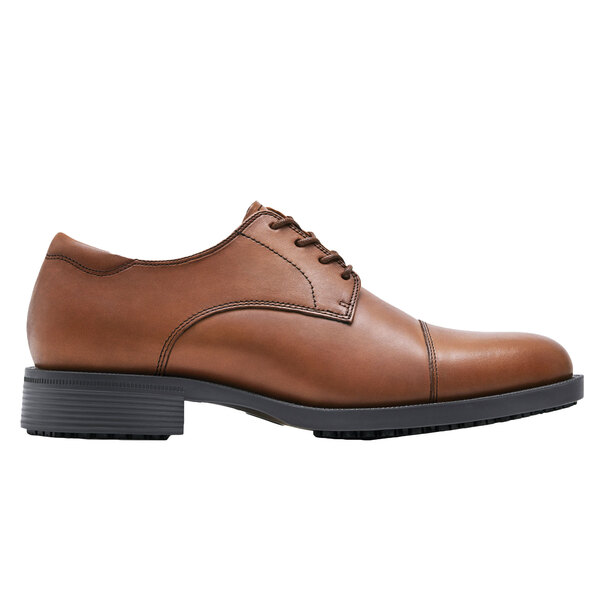A brown leather Shoes For Crews men's derby shoe with a black sole.