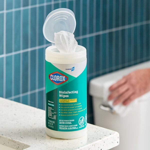 A container of CloroxPro Clorox disinfecting wipes with the lid open and a wipe partially pulled out.