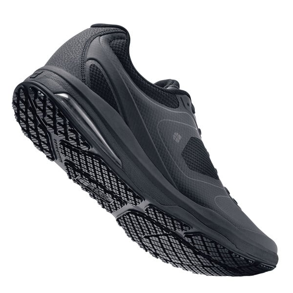 A black Shoes For Crews athletic shoe with a white background.