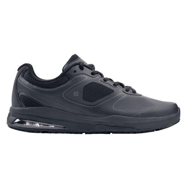 A black Shoes For Crews Evolution II men's athletic shoe with laces on a table.