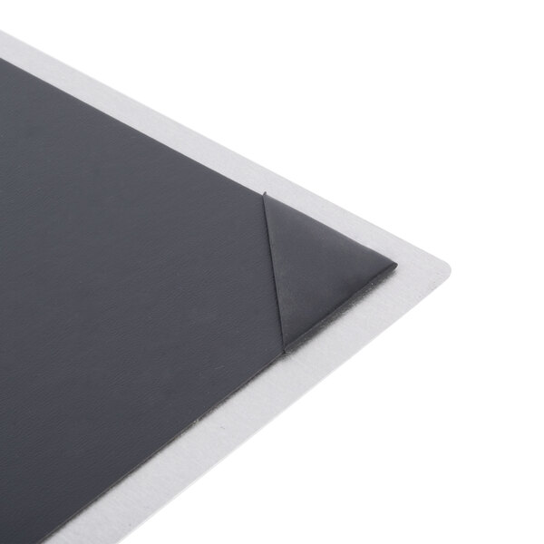 The corner of a black menu board with silver picture corners.