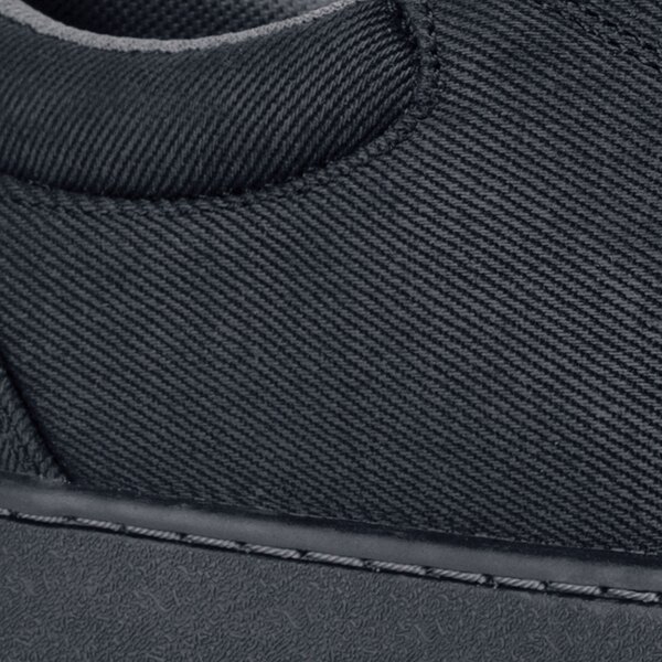 A side view of a black Mozo casual shoe with a zipper on the side.