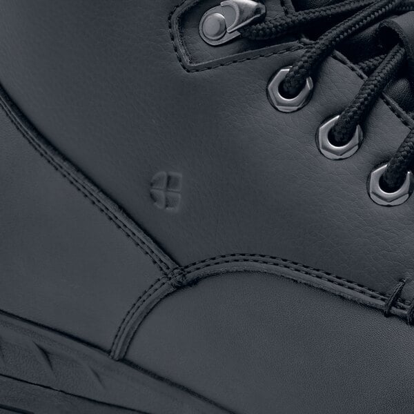 A close up of a black Shoes For Crews steel toe work boot with laces.