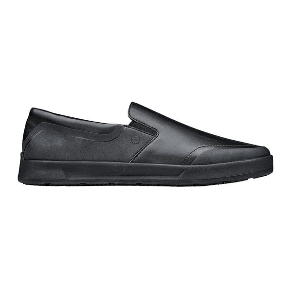 A black Shoes For Crews men's slip-on shoe with a rubber sole.