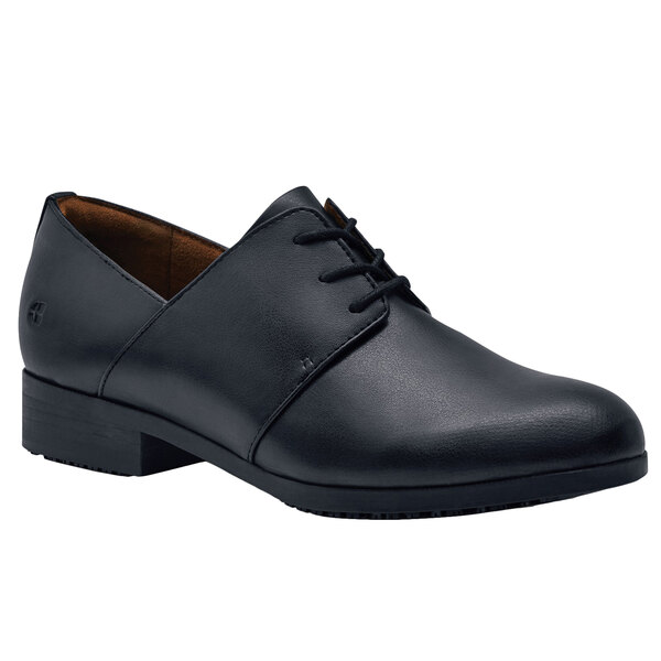 A black Shoes For Crews women's dress shoe with laces.