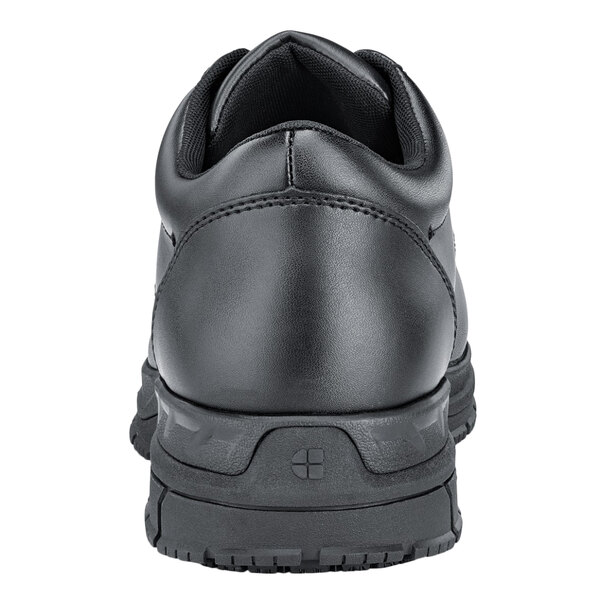 A close up of a black leather Shoes For Crews work boot with a rubber sole.