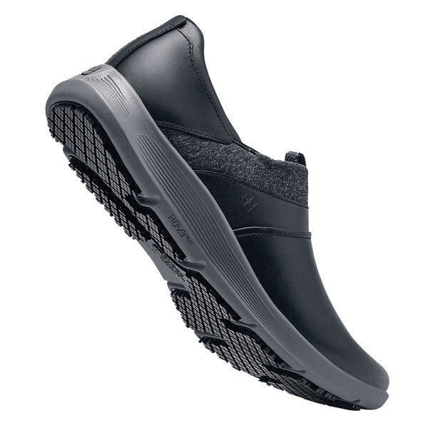 A close up of a black Women's Shoes For Crews Alia slip on shoe with a sole.