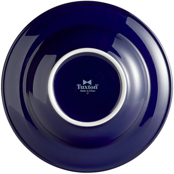 A Tuxton cobalt blue china bowl with a white rim.