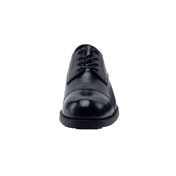 A close-up of a black Shoes For Crews Senator dress shoe with laces.