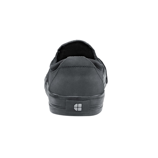 A close-up of a black Shoes For Crews slip-on shoe with a logo on it.