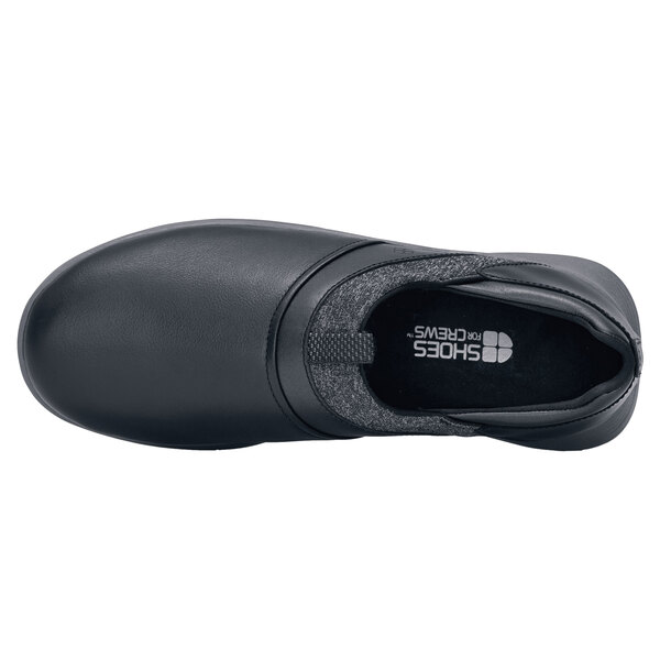 A black Shoes For Crews Alia women's slip-on shoe with a white non-slip sole.