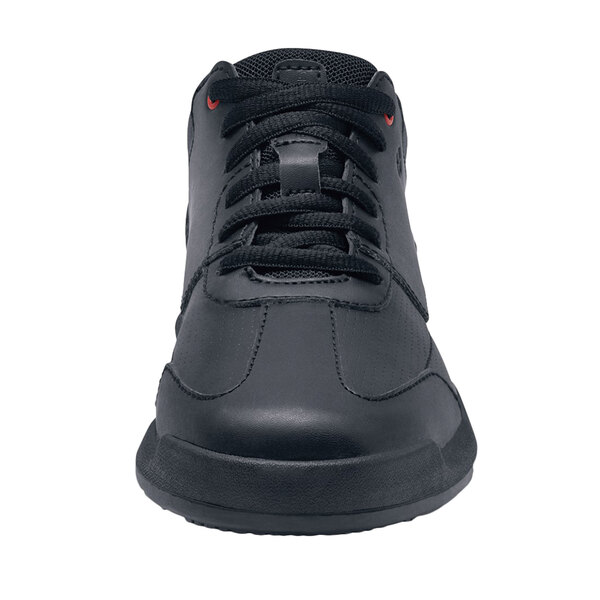 A close up of a black Shoes For Crews Liberty Women's non-slip athletic shoe with red laces.
