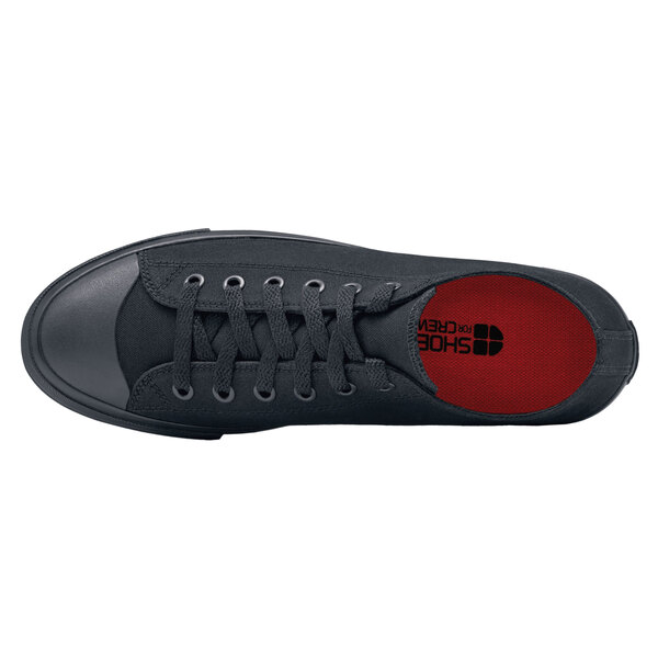 A black Shoes For Crews Delray casual shoe with red soles and laces.