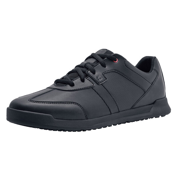 A black leather Shoes For Crews athletic shoe with laces.