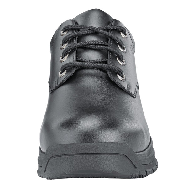 A black Shoes For Crews work boot with laces and a rubber sole.