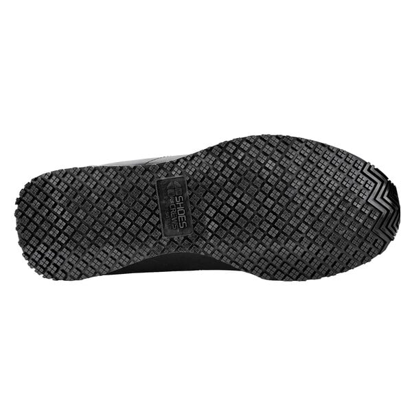 The textured sole of a black Shoes For Crews Avery athletic shoe.