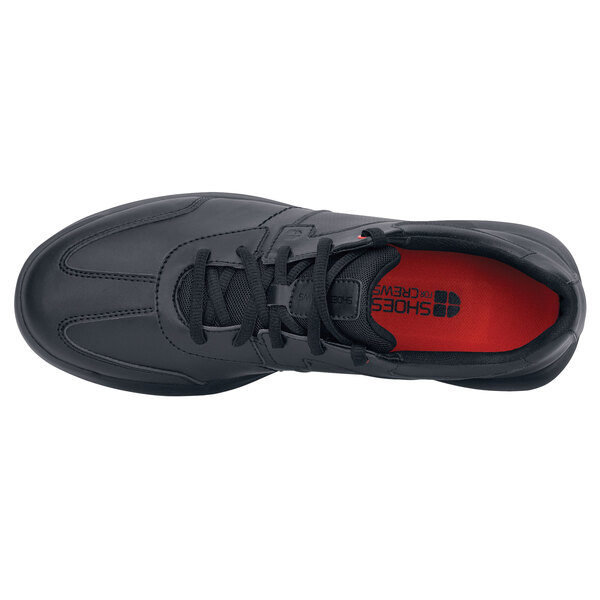 A black Shoes For Crews Freestyle II shoe with a red sole.
