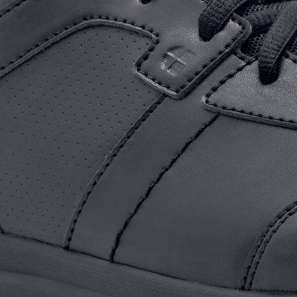 A black leather Shoes For Crews Freestyle II athletic shoe with a rubber sole and zipper.