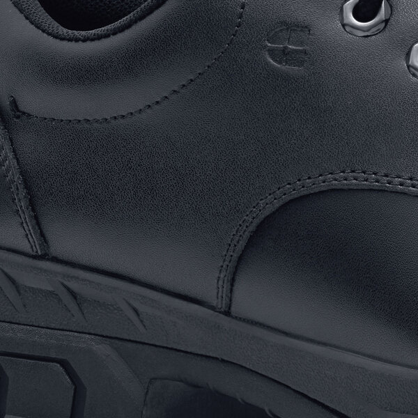 A close up of a black Shoes For Crews Cade work shoe with a rubber sole.