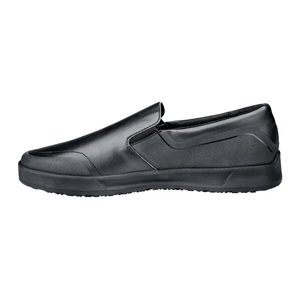 A pair of black Shoes For Crews slip on shoes with a rubber sole.