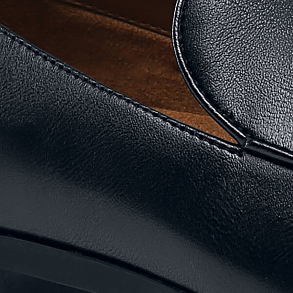 A black leather Shoes For Crews Riley loafer with a rubber sole.