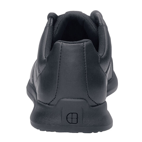 A black Shoes For Crews athletic shoe with white background.