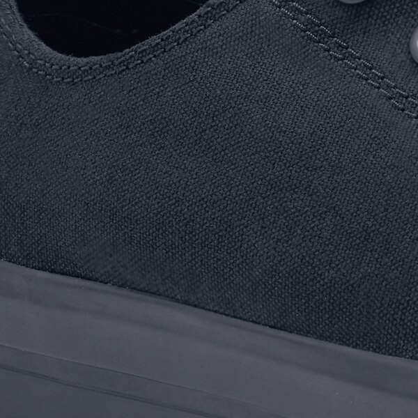 A close up of a black Shoes For Crews Delray non-slip casual shoe on a table.