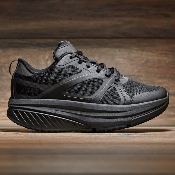 a black shoe on a wood surface