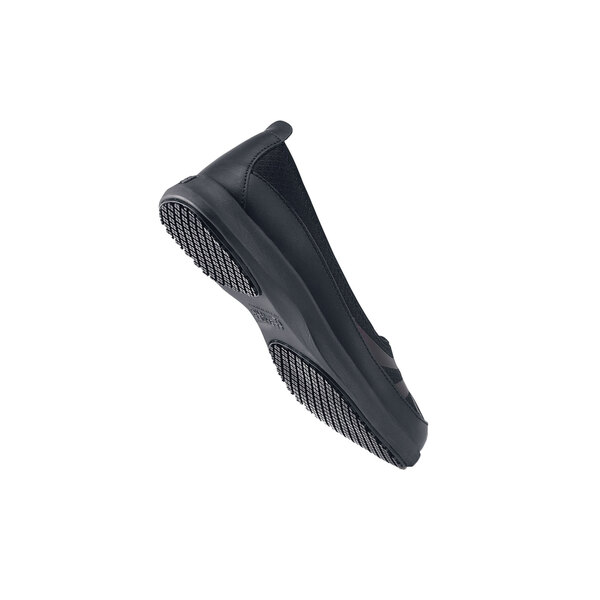 A close-up of a black Shoes For Crews Yogi women's shoe with a rubber sole.