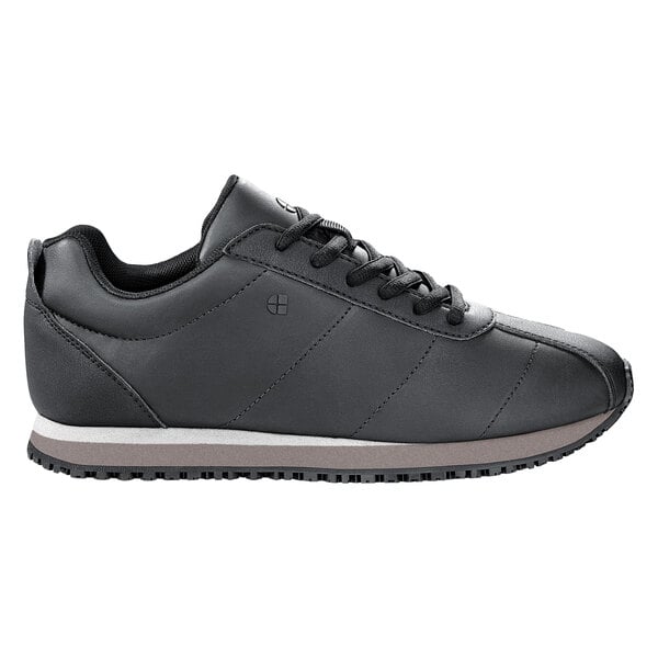 A black Shoes For Crews women's athletic shoe with a white sole.