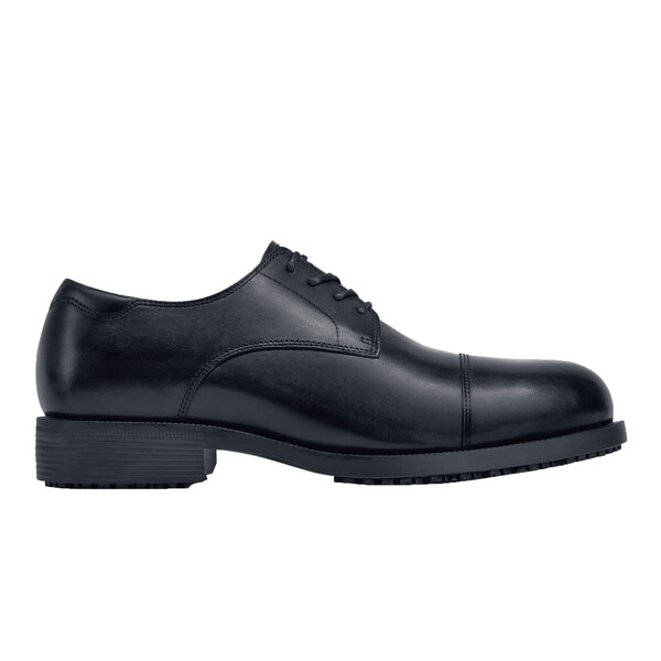 A black leather Shoes For Crews Senator dress shoe with a rubber sole.