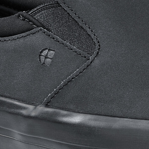 A close up of a black Shoes For Crews Ollie II slip-on shoe.