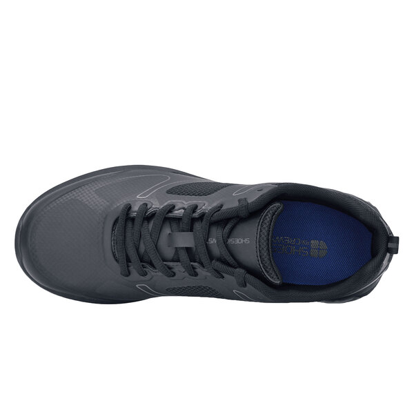 A close-up of a black Shoes For Crews Revolution II women's athletic shoe with a black sole.
