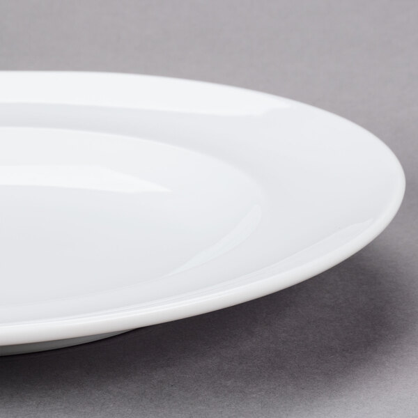 An Arcoroc white porcelain dinner plate with a rim.