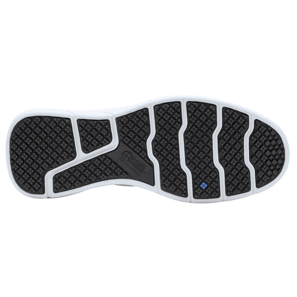 The white sole of a white and black Shoes For Crews Karina athletic shoe.