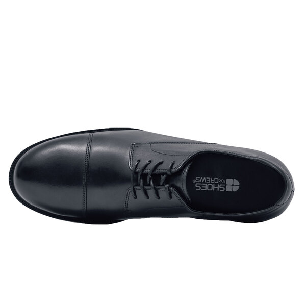 A black leather Shoes For Crews steel toe shoe with laces.
