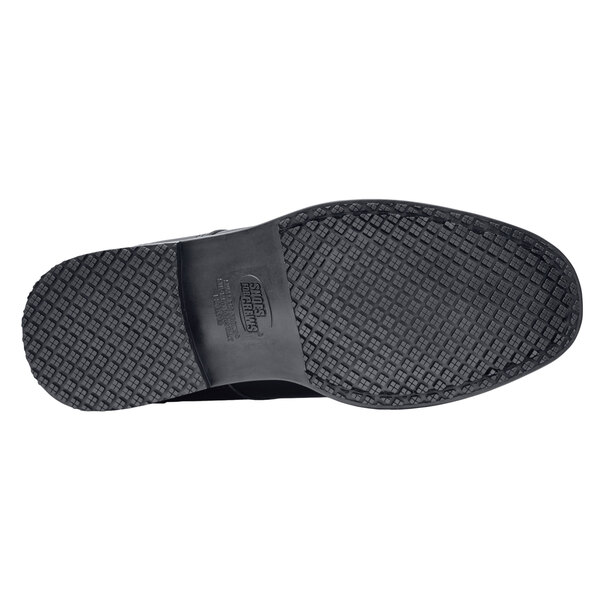 The bottom of a black Shoes For Crews Cambridge men's dress shoe.