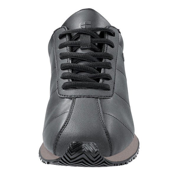 A close-up of a black leather Shoes For Crews Avery women's athletic shoe with black laces.