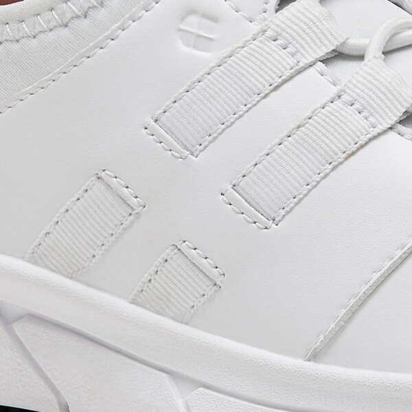 A close up of a white Shoes For Crews Karina athletic shoe with black laces.
