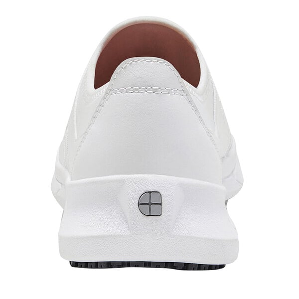 A white Shoes For Crews Karina athletic shoe with a black sole and a logo on the bottom.