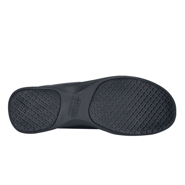 A close-up of a black Shoes For Crews Yogi casual shoe with a white background.