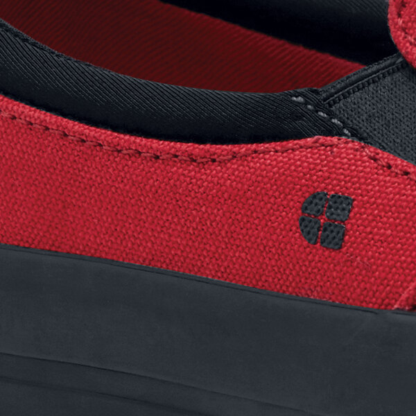 A close up of a red and black Shoes For Crews Ollie II men's canvas shoe with a black sole.