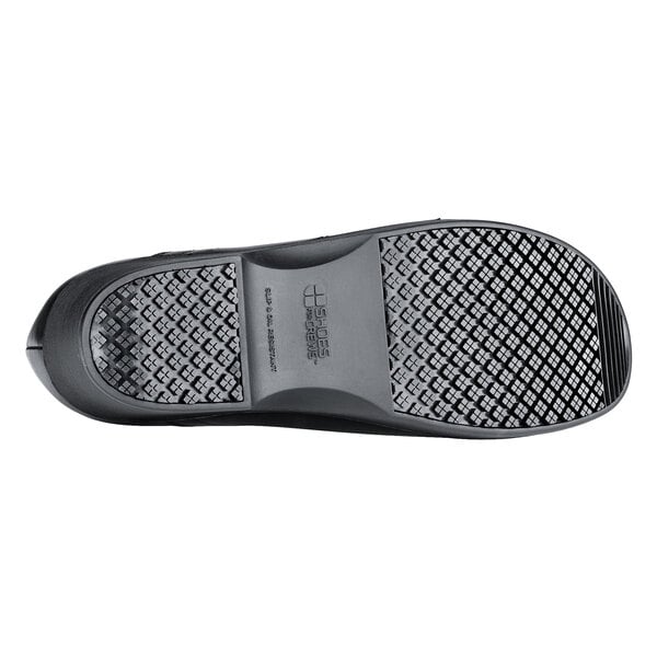 A close-up of a black Shoes For Crews Juno women's shoe with a black and patterned sole.
