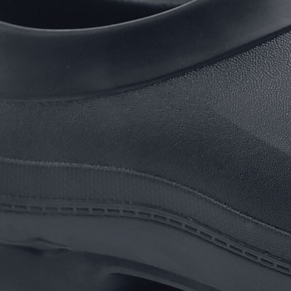 A close up of a black Shoes For Crews shoe with a rubber sole.