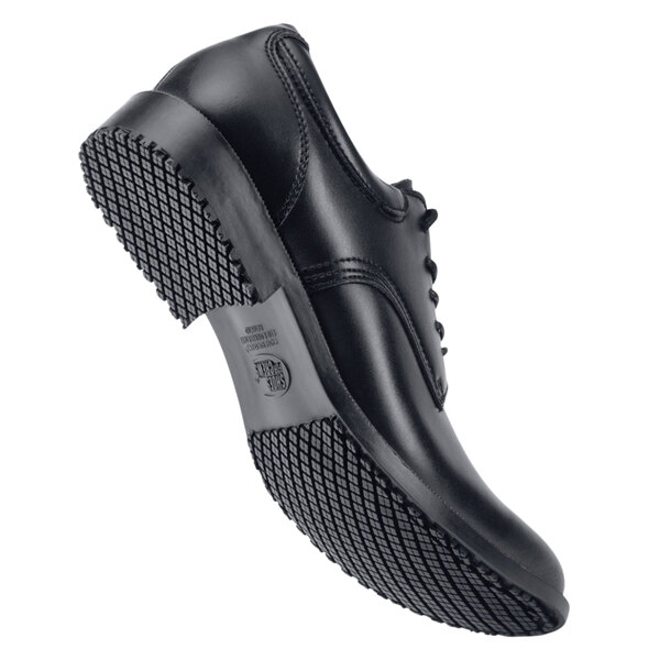 A black Shoes For Crews Cambridge dress shoe with rubber soles.
